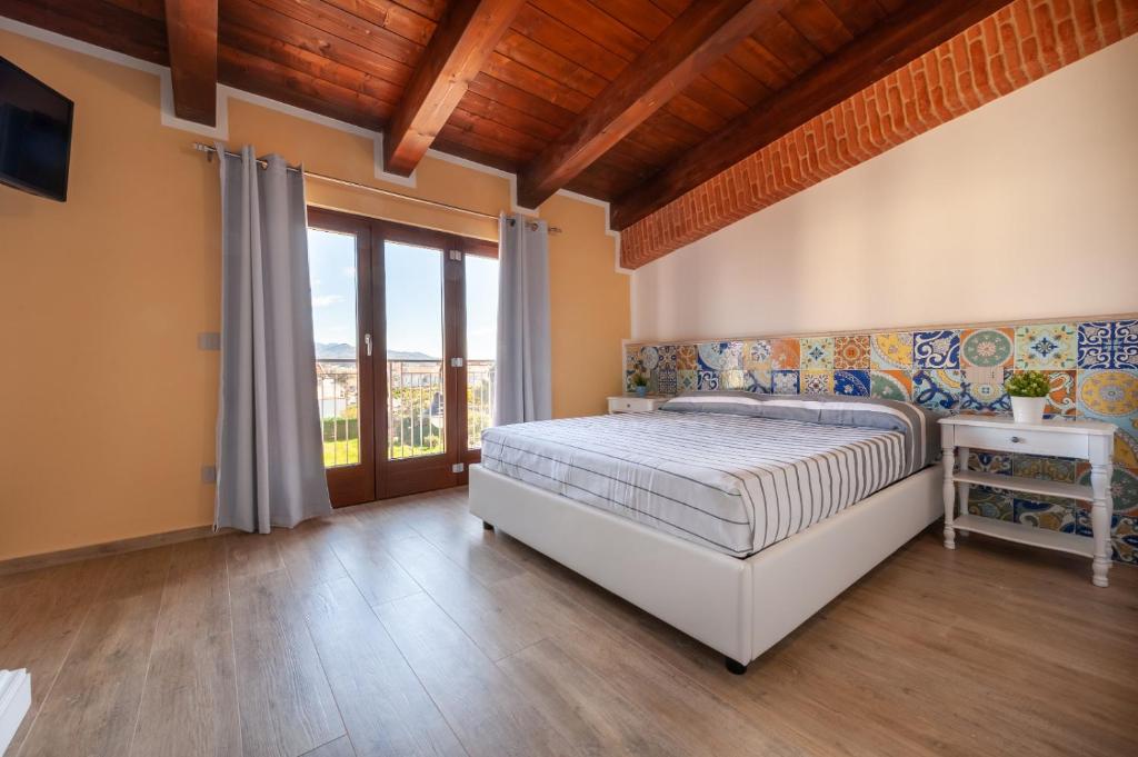 a bedroom with a bed and a large window at Holiday Mulas in Marina di Casalvelino
