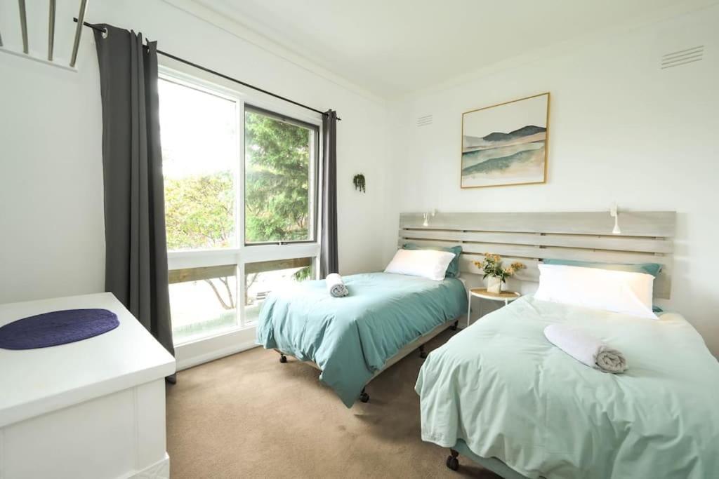 1 dormitorio con 2 camas y ventana en Casa La Mer 2 Bdr Apartment with Ocean view, en Cowes