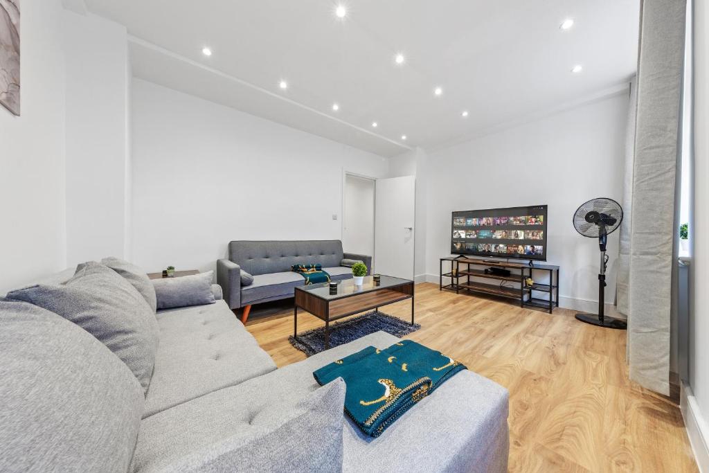 a living room with a couch and a tv at Modern Flat near Hyde Park in London