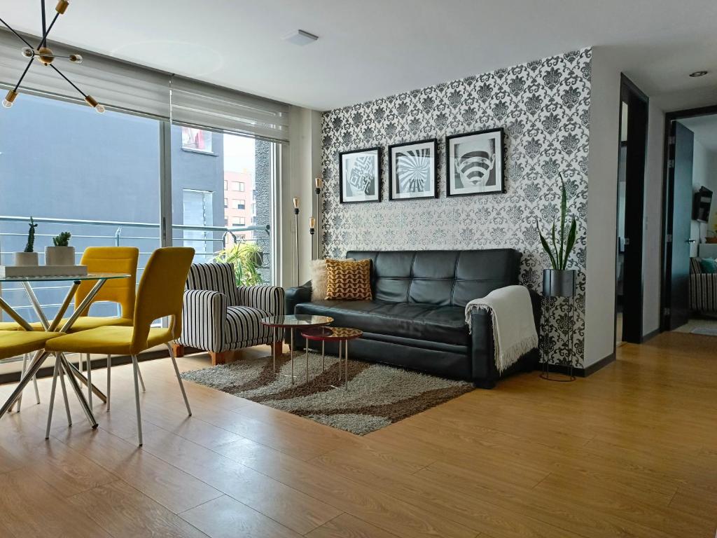 uma sala de estar com um sofá, uma mesa e cadeiras em Like a Home with Balcony - 7Th FLOOR - Parking - Gym em Quito