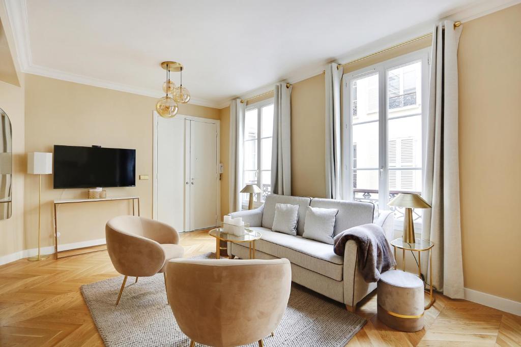 un salon avec un canapé et une télévision dans l'établissement Pick A Flat's Apartments in Opéra Saint Lazarre - Rue de l'Isly, à Paris