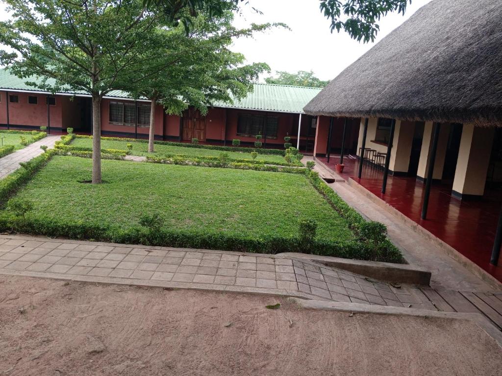 a building with a courtyard with a tree in the yard at Kamutamba guesthouse in Masaiti