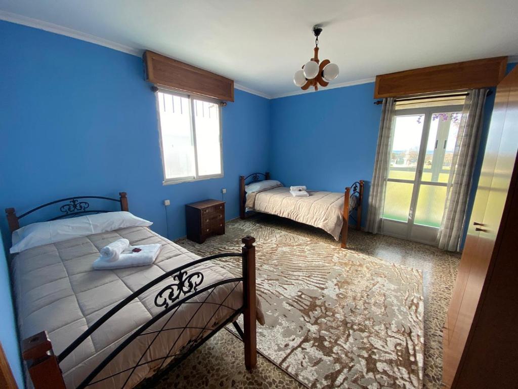 1 dormitorio con paredes azules y 2 camas. en Balcones de Madrid, en Parada del Sil