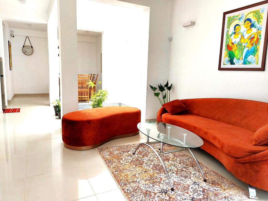 a living room with a red couch and a table at OESIS - Stylish Holiday Home in the heart of Galle in Galle