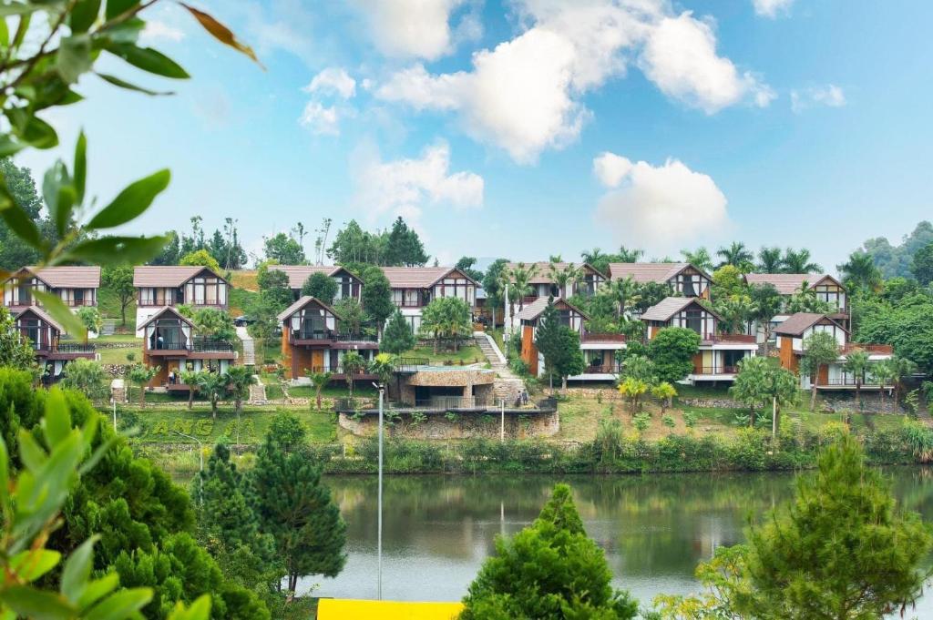 Thang Mây Village Rersort في بافي: مجموعة منازل بجانب البحيرة