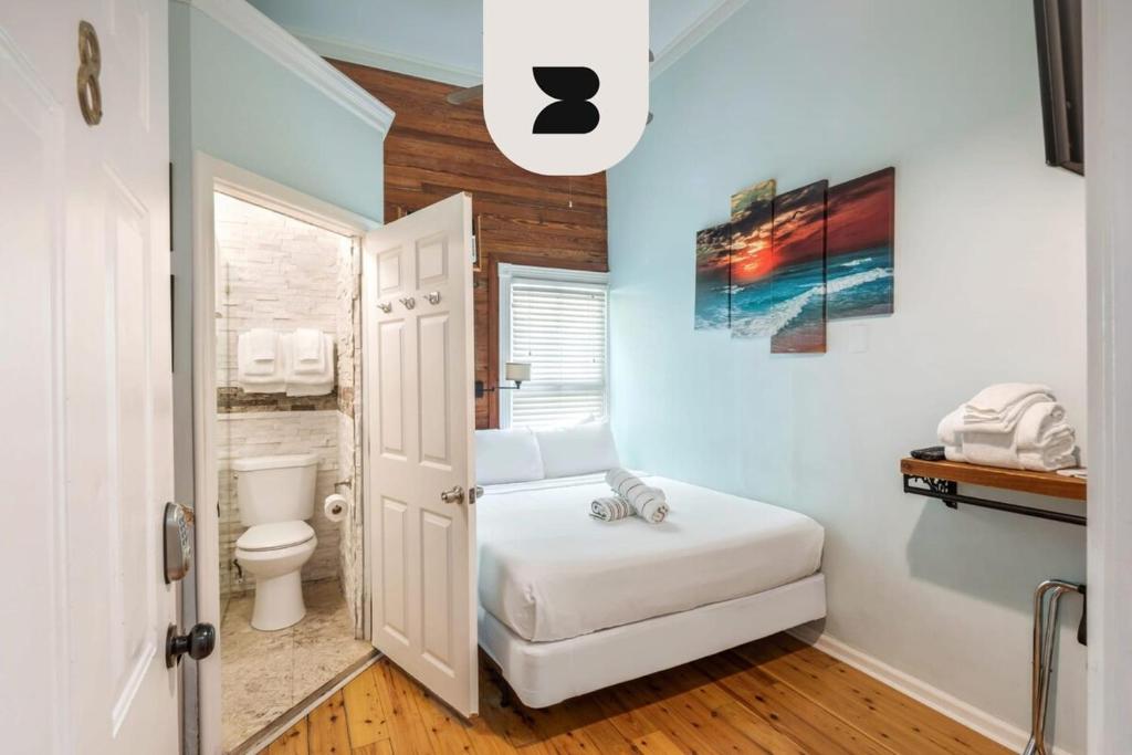 a small bathroom with a bed and a toilet at NEW VanGogh Studio by Brightwild- Pool & Balconies in Key West