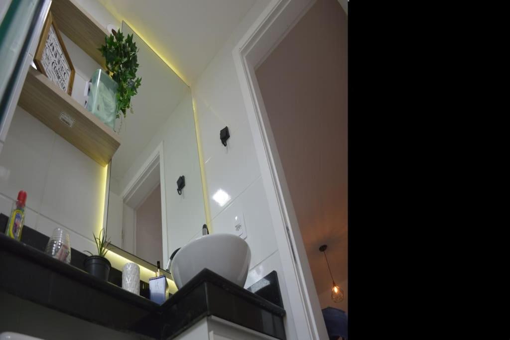 a kitchen with a counter with an apple on the wall at Apartamento Marilândia Juiz de Fora in Juiz de Fora