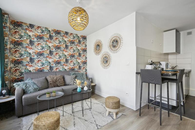 a living room with a couch and a kitchen at 852 Suite Élégante - Superb Apartement in Asnières-sur-Seine