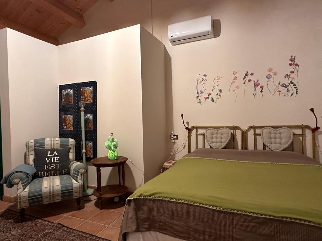sypialnia z zielonym łóżkiem i krzesłem w obiekcie Cascina La Vigna Country House w mieście Citta' Sant'Angelo