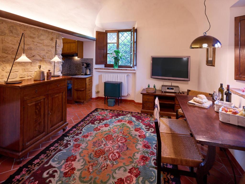 salon ze stołem i telewizorem w obiekcie Agriturismo Podere Cortilla w mieście Volterra