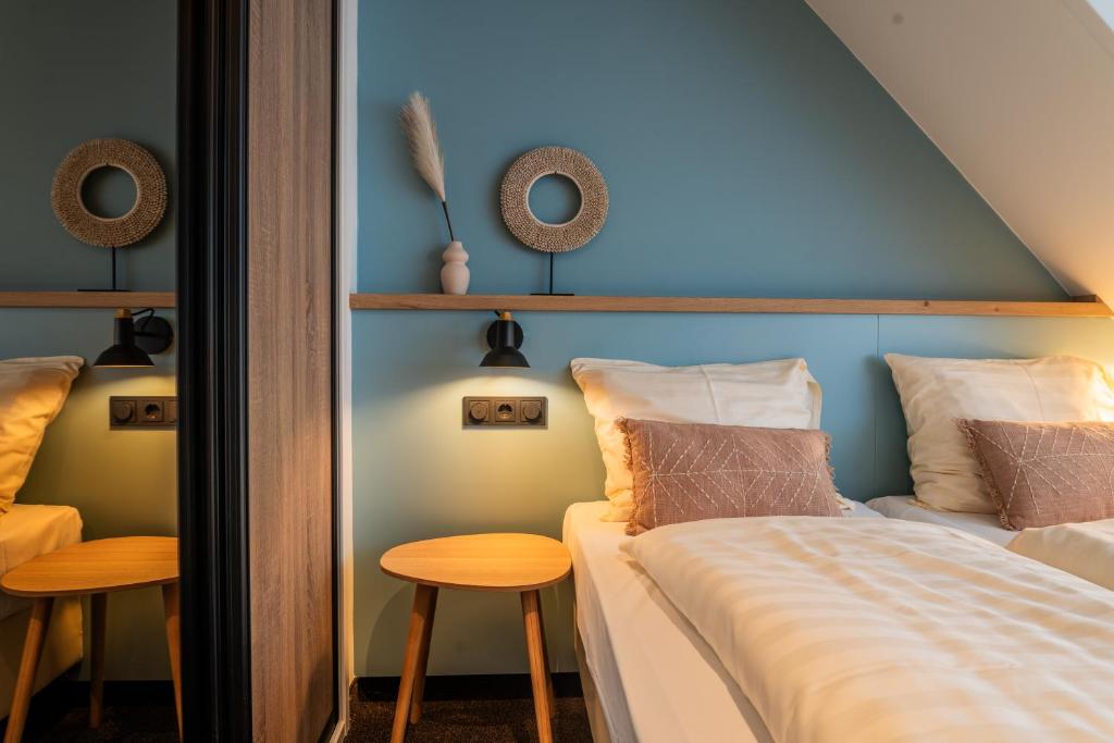 um quarto com uma cama, uma mesa e cadeiras em Huis 8 Studio's em Katwijk aan Zee