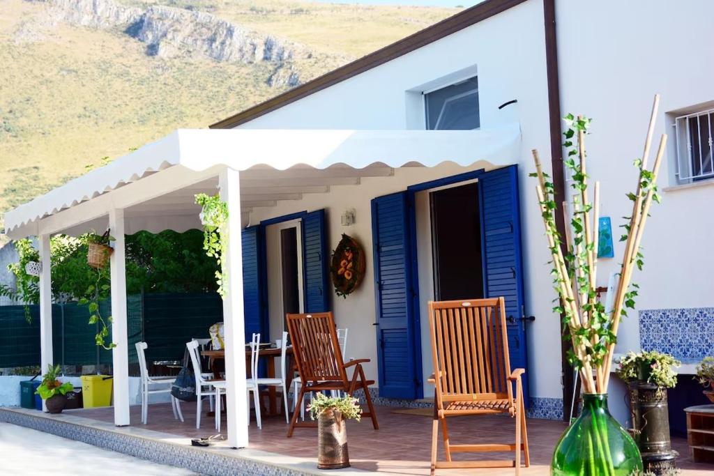 a blue and white house with chairs and a table at Violisa Charme in Castellammare del Golfo