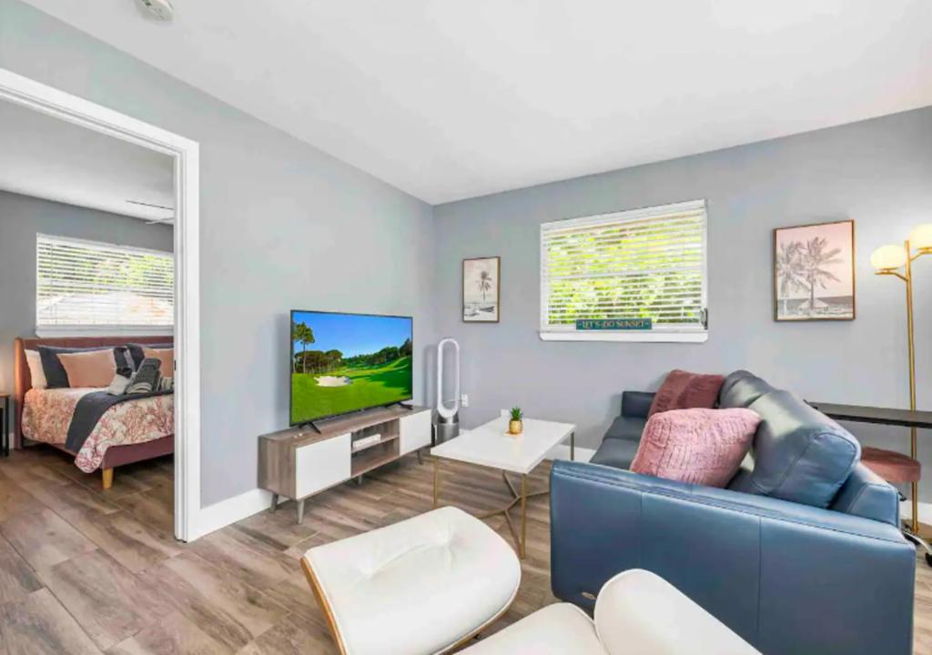 a living room with a blue couch and a tv at Stunning 1 BD 1BA In Naples in Naples