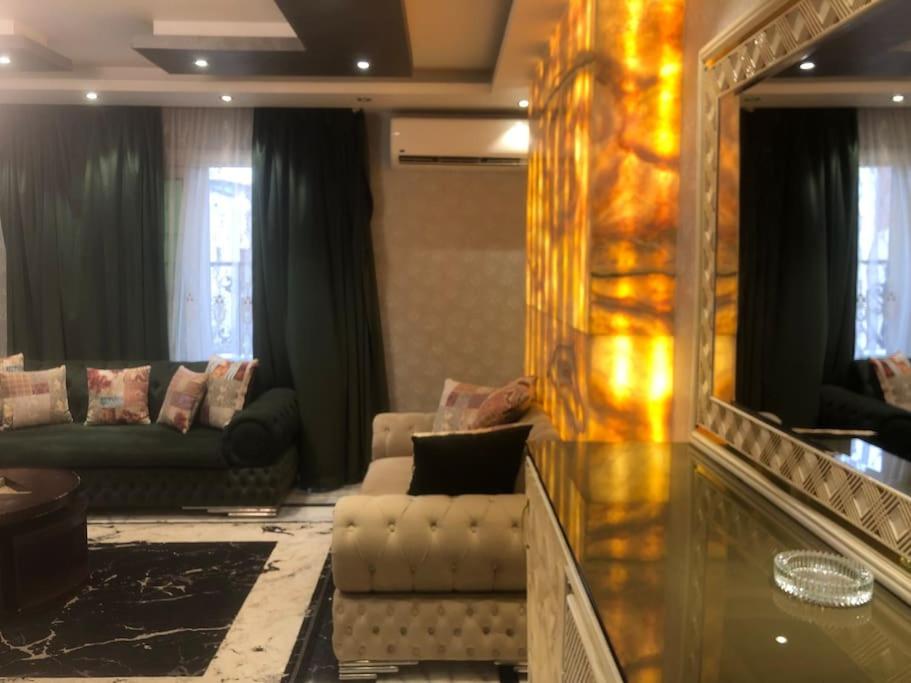 a living room with a couch and a mirror at Luxury family apartment in Cairo