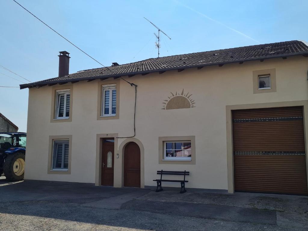 uma casa com duas portas de garagem e um banco na frente em Gîte Franconville, 3 pièces, 4 personnes - FR-1-584-181 