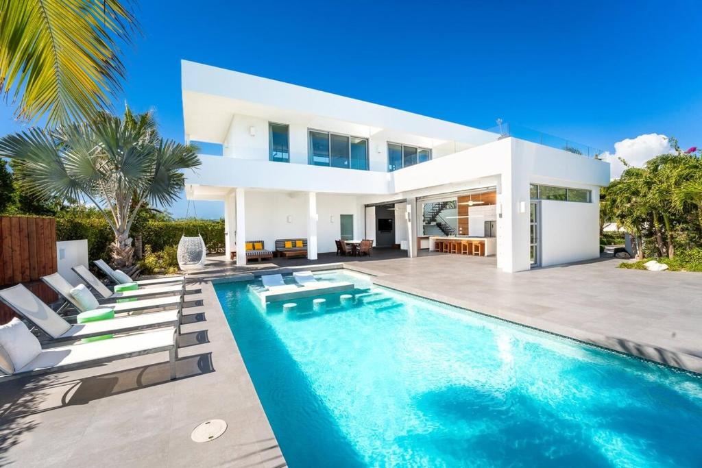 a villa with a swimming pool and a house at Oceanside 3 Bedroom Luxury Villa with Private Pool, 500ft from Long Bay Beach -V2 in Providenciales