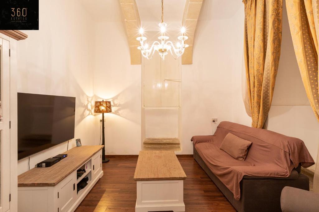 - un salon avec un canapé et une télévision dans l'établissement Palazzo EL Cattedrale in historic MDINA by 360 Estates, à Mdina