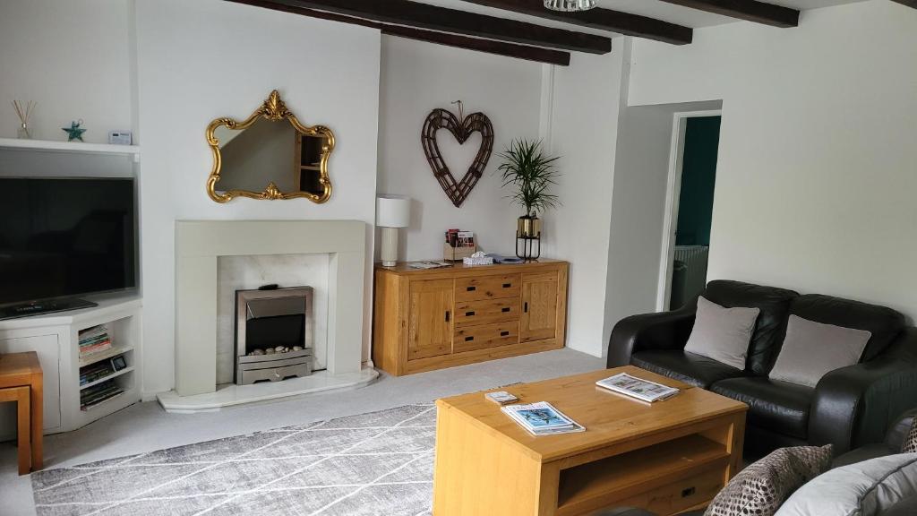 Coatham Cottage في Barton: غرفة معيشة مع أريكة ومدفأة