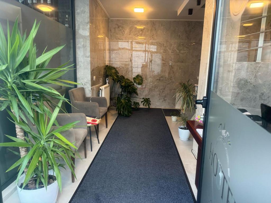 a corridor with plants in a waiting room at Hotel Uniluxury in Pristina