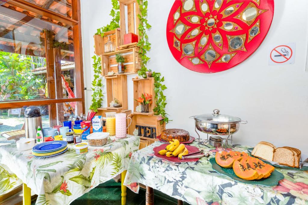 a dining room with a table with food on it at Drifter Hostel in Barra do Sahy
