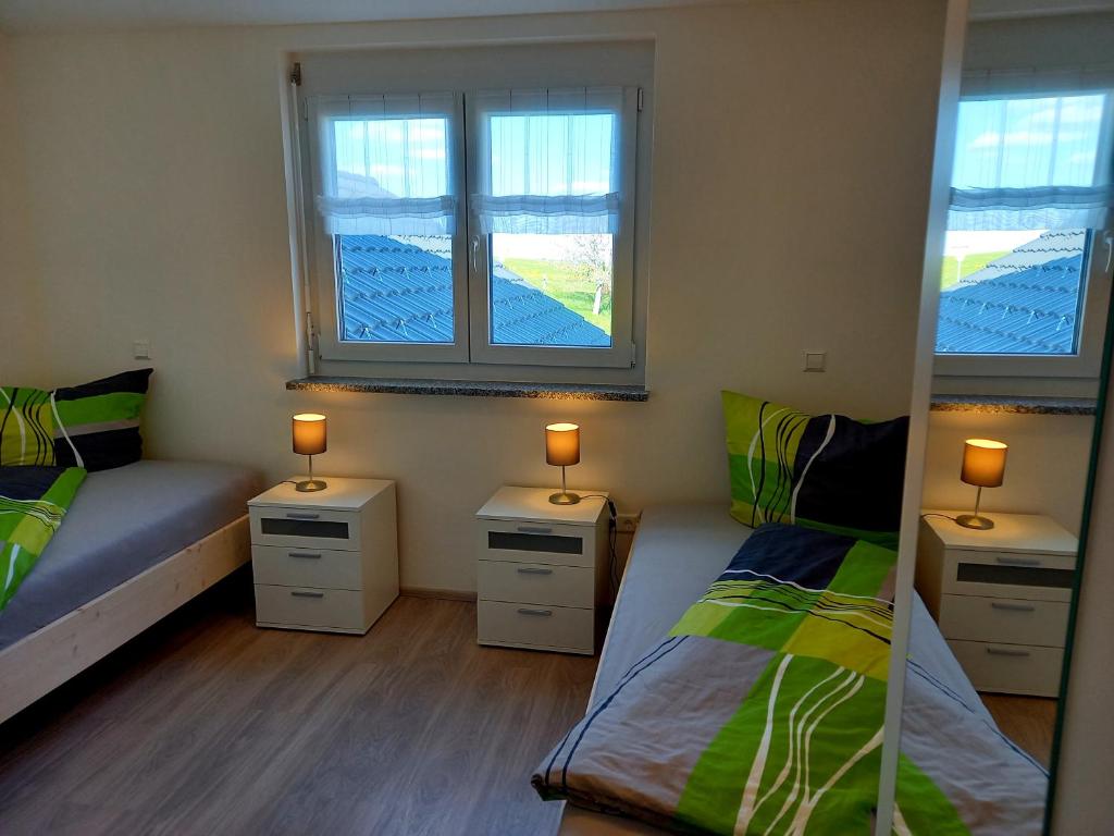 1 dormitorio con 2 camas individuales y 2 ventanas en Haus Fernsicht Wohnung Bergpanorama en Höchenschwand