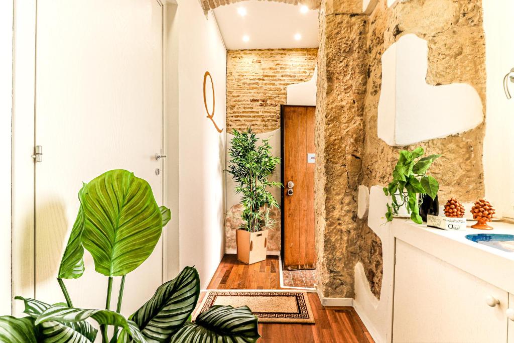 a hallway with potted plants in front of a door at B&B Qaral in Cagliari