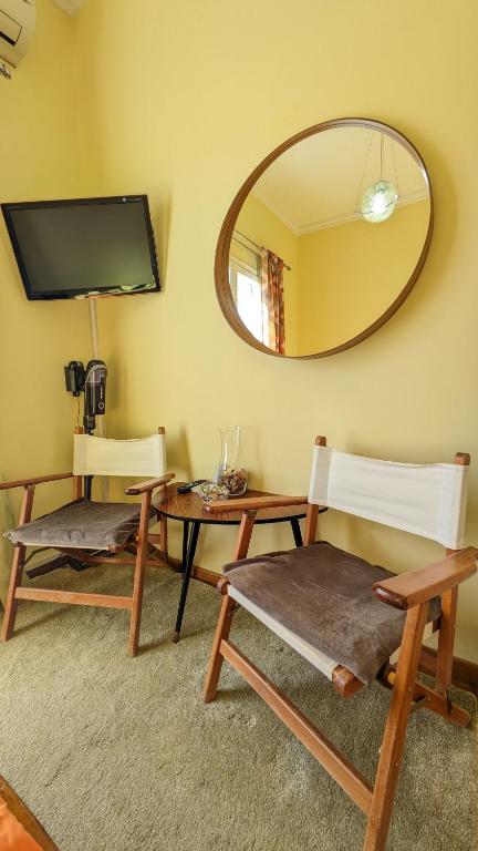 Pokój z 2 krzesłami, stołem i lustrem w obiekcie Small House for Holidays w mieście Leonidion