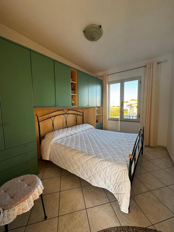 - une chambre avec un grand lit et une fenêtre dans l'établissement Mandras 2, à La Caletta