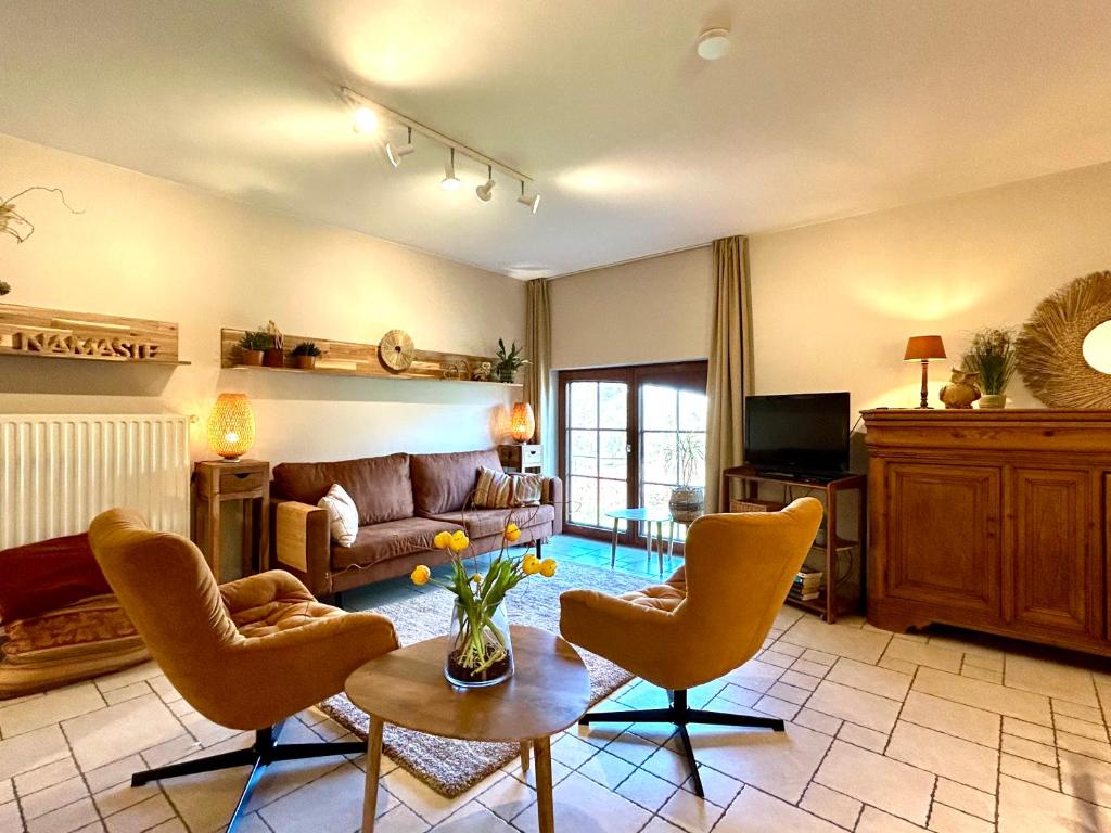 Au Coeur Des Collines, Chouette في Ellezelles: غرفة معيشة مع أريكة وكراسي وطاولة