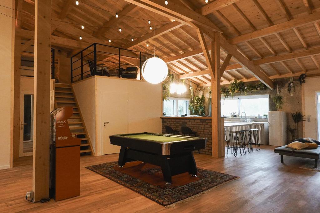- un salon avec un billard et un escalier dans l'établissement FHandCO, Loft and Music Studio, à Damas-aux-Bois