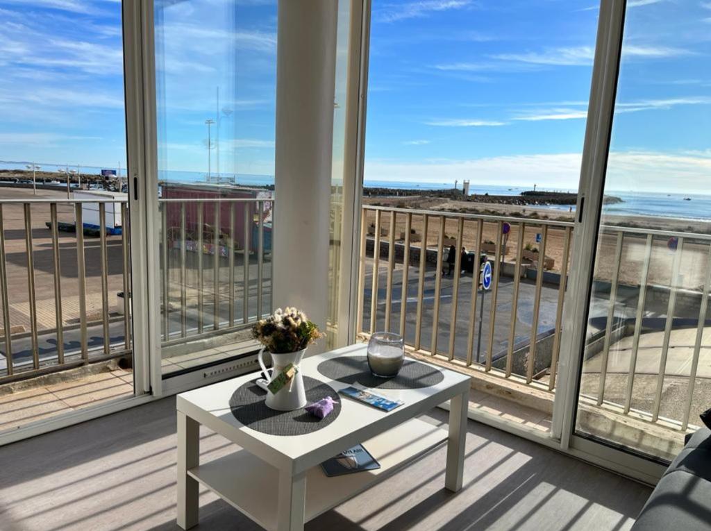 einen Tisch auf dem Balkon mit Blick auf den Strand in der Unterkunft Studio magnifique vue mer et port in Valras-Plage