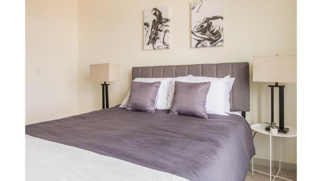 a bedroom with a large bed with purple sheets and pillows at Stunning Nulu 1BR CozySuites 03 in Louisville