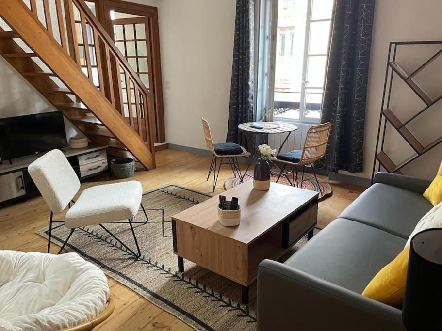 un salon avec un canapé et une table basse dans l'établissement Le Duplex de la Reine - T3 Cosy au cœur de Chambéry, à Chambéry