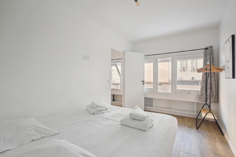 a white bedroom with a large bed and a window at 199 Suite Monopoly - Superb Apartment in Paris in Paris