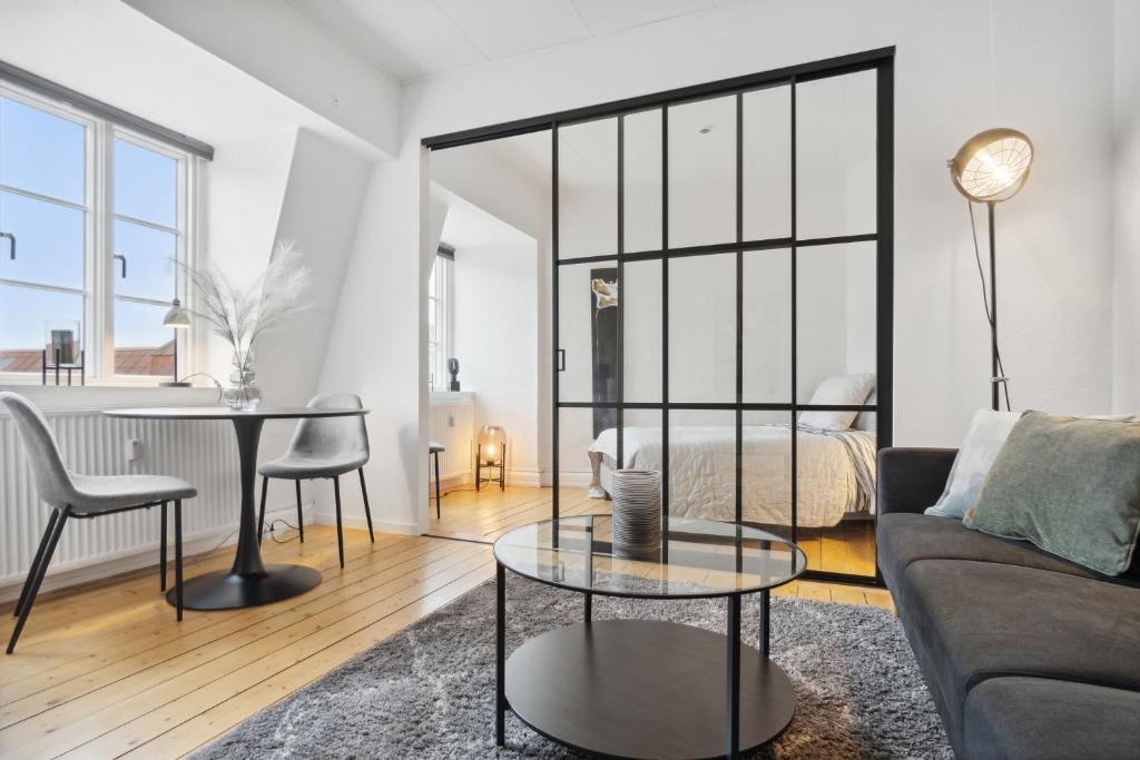 ein Wohnzimmer mit einem Sofa und einem Tisch in der Unterkunft New Yorker 2 BR lejlighed tæt på Aalborg Centrum in Aalborg