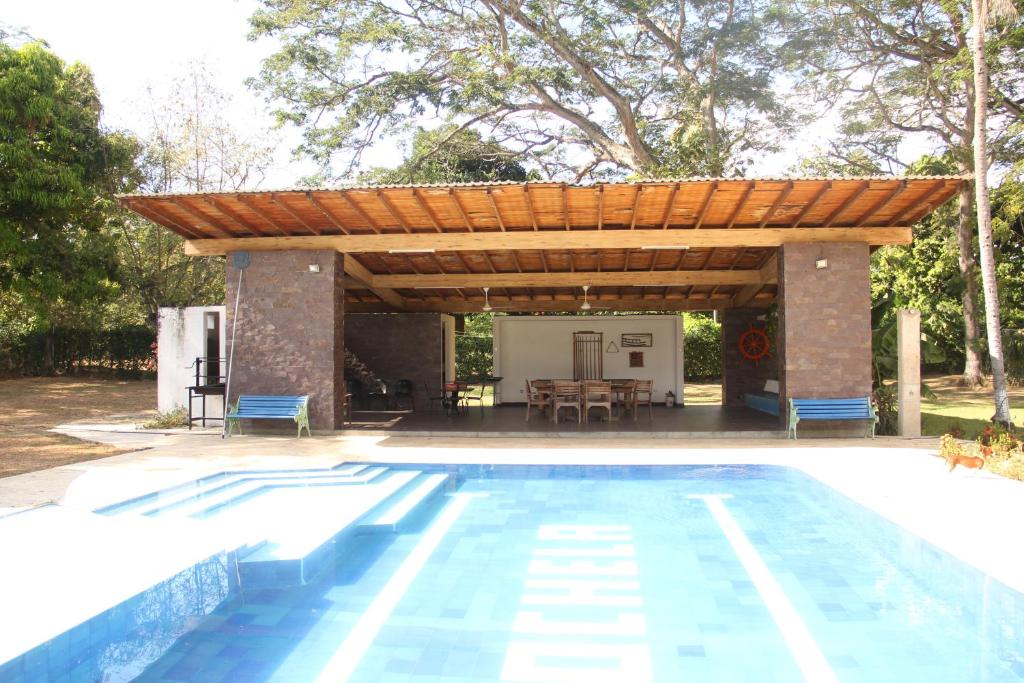 a pergola over a swimming pool with a house at Hermosa Finca La Rochela, Santa fe de Antioquia in Santa Fe de Antioquia