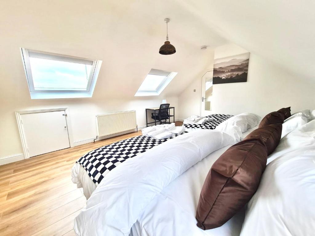 two large white beds in a room with skylights at Beautiful quiet Victorian Bungalow heart of London in London