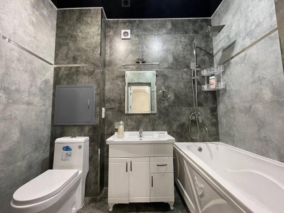 een badkamer met een toilet, een wastafel en een bad bij City Plaza Zebo in Samarkand