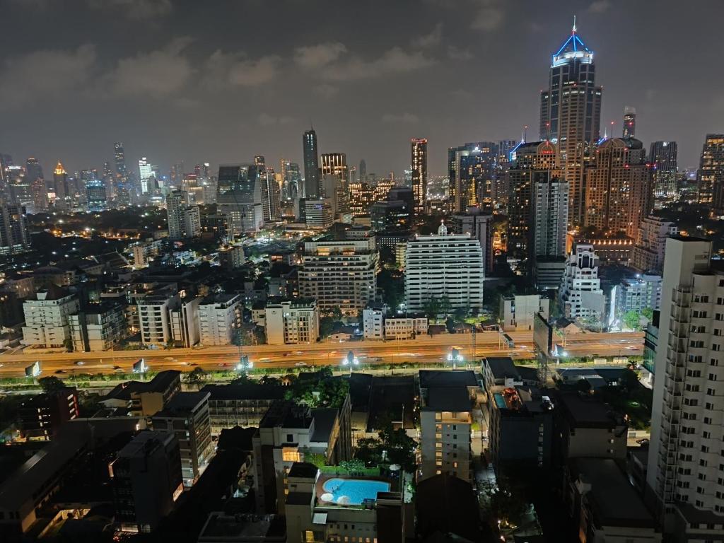 Omni Tower Sukhumvit Nana by Direct Rooms في بانكوك: اطلالة على مدينة بالليل مع