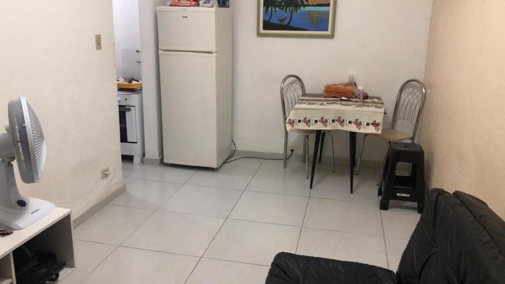 uma cozinha com uma mesa e um frigorífico branco em UINQUEND em São Vicente