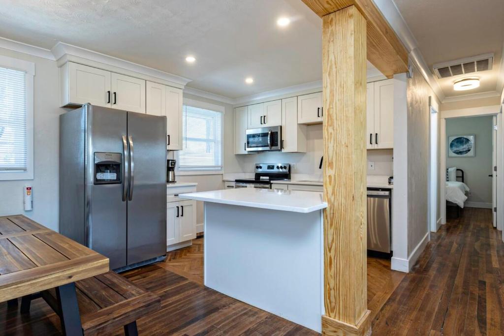 a kitchen with a stainless steel refrigerator and a table at The Beach Vibe with Hot tub 8 min to the Beach in Virginia Beach