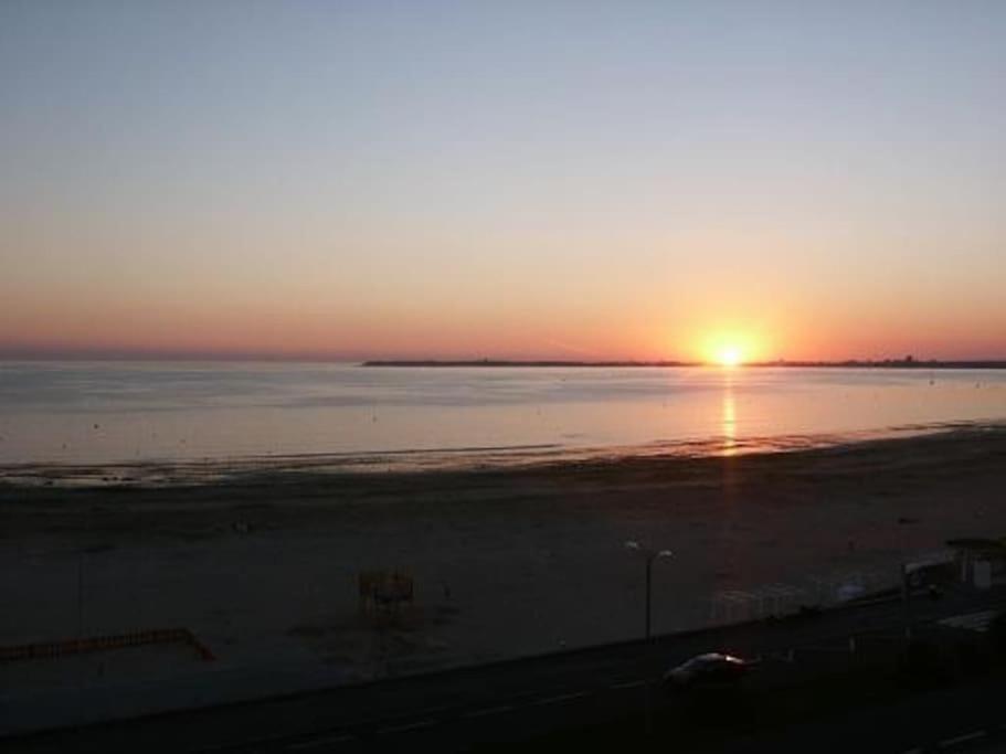 - un coucher de soleil sur une plage et un coucher de soleil sur l'eau dans l'établissement FACE MER PORNICHET BAIE DE LA BAULE GRAND STUDIO, à Pornichet