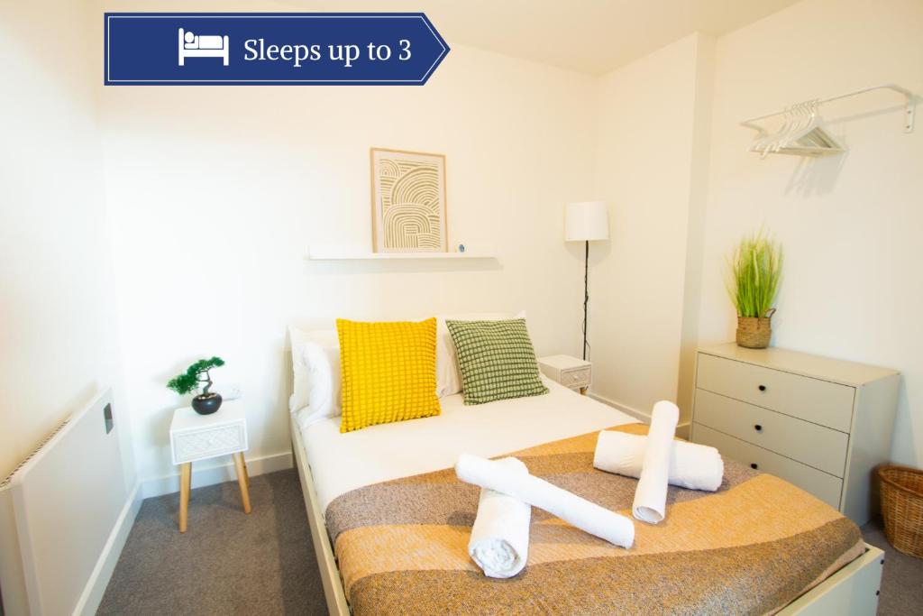 ein Schlafzimmer mit einem Bett mit Handtüchern darauf in der Unterkunft Bright & Cosy Penthouse in Old Trafford in Manchester