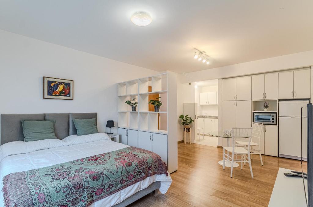 a bedroom with a large bed and a kitchen at Hermoso Departamento en Palermo! in Buenos Aires