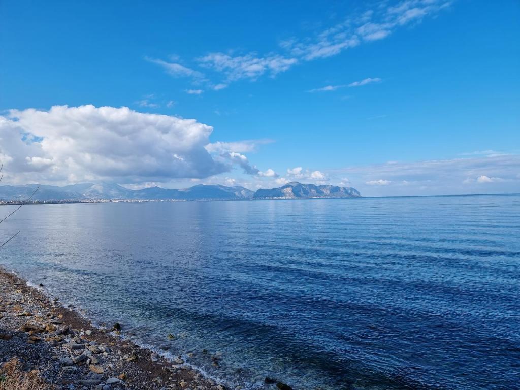 uma vista para o oceano com montanhas ao fundo em Il Paradiso di Rosalba by Holiday World em Ficarazzi