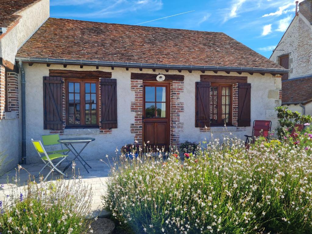 un cottage avec un jardin en face dans l'établissement Roulotte confortable avec balcon en bois, climatisation et prêt de vélos, près du Château de Sully - FR-1-590-287, à Bonnée