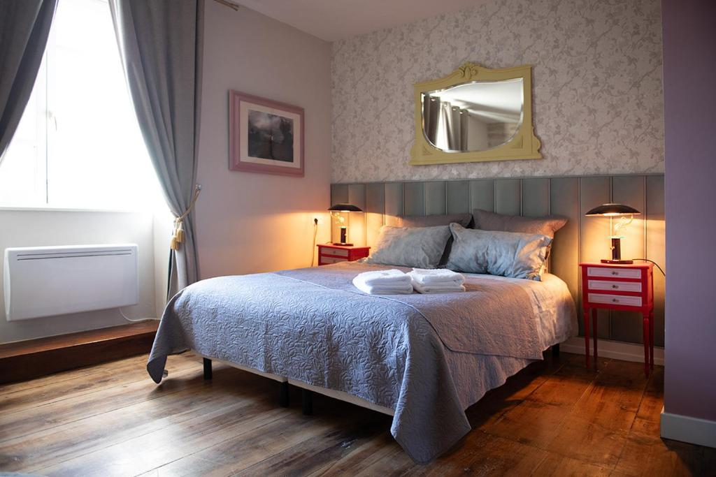 a bedroom with a bed with a mirror on the wall at Pat à Touille in Treignac
