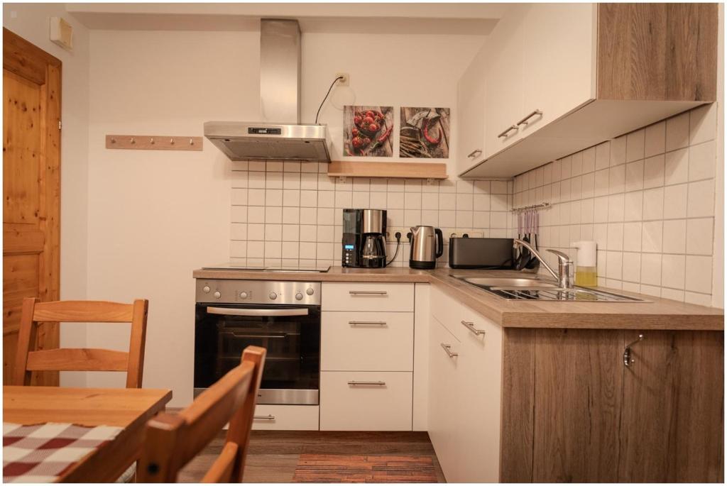 a kitchen with a stove and a sink and a table at Appartement Franz in Bad Ischl