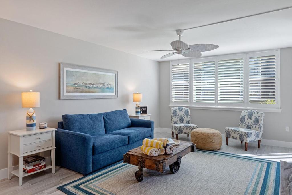 a living room with a blue couch and a table at Loggerhead 261 in Sanibel