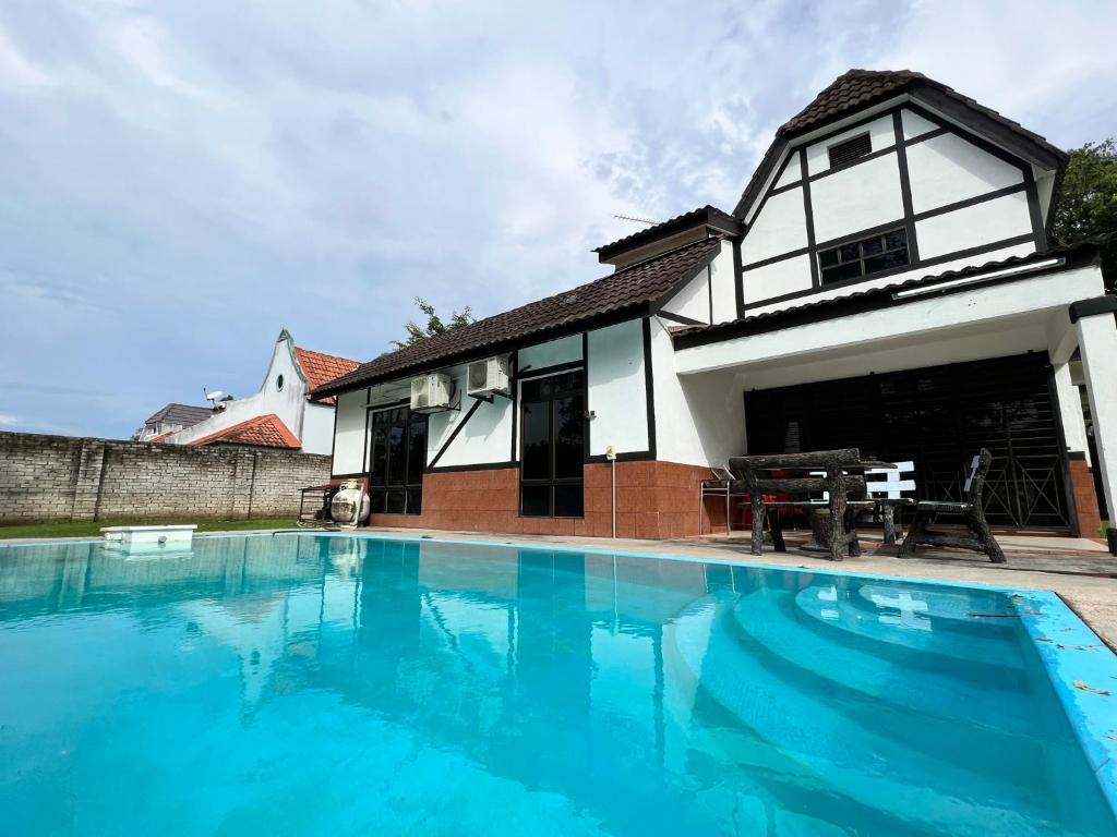 a house with a swimming pool in front of it at Private Pool Villa Lot 872 - Fong Homestay in Kampong Alor Gajah